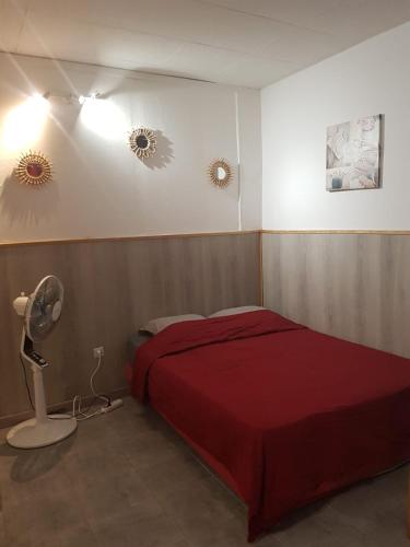 - une chambre avec un lit rouge et un ventilateur dans l'établissement STUDIO ENTRE PARIS et DISNEY 2, à Torcy