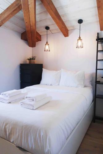 a bedroom with a white bed with two towels on it at Qué bueno que viniste Plasencia Edificio Singular in Plasencia