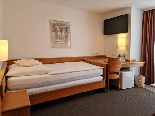 a hotel room with a bed and a desk at Hotel Gerberhof in Backnang