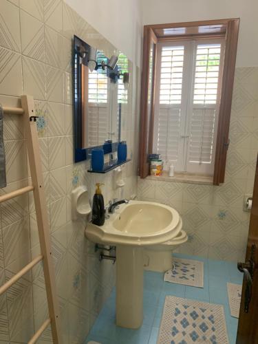 Un baño con un lavabo blanco y un espejo. en A... Mare Sicilia, en Marina di Modica