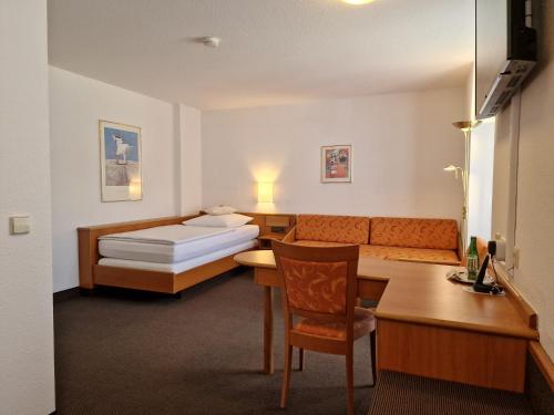 a hotel room with a bed and a desk at Hotel Gerberhof in Backnang