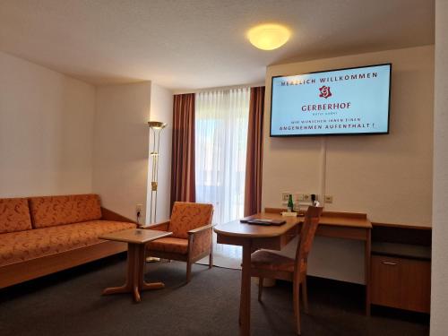 a room with a couch and a table and a screen at Hotel Gerberhof in Backnang