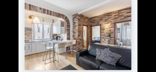 a living room with a black couch and a kitchen at Queen East Verona apartments in Verona