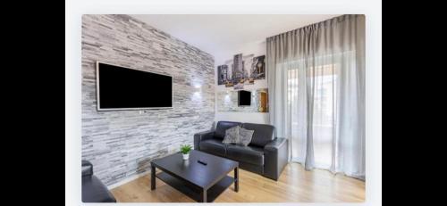 a living room with a couch and a brick wall at Queen East Verona apartments in Verona