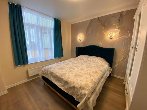 a bedroom with a bed and a window at Нові апартаменти по вулиці Роксолани16 in Truskavets