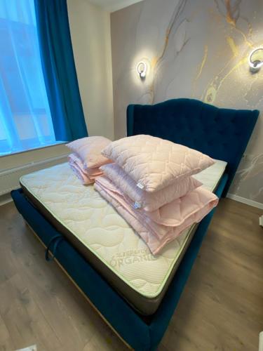 a bed with pink sheets and pillows on it at Нові апартаменти по вулиці Роксолани16 in Truskavets
