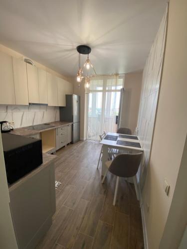a kitchen with a table and chairs in a room at Нові апартаменти по вулиці Роксолани16 in Truskavets