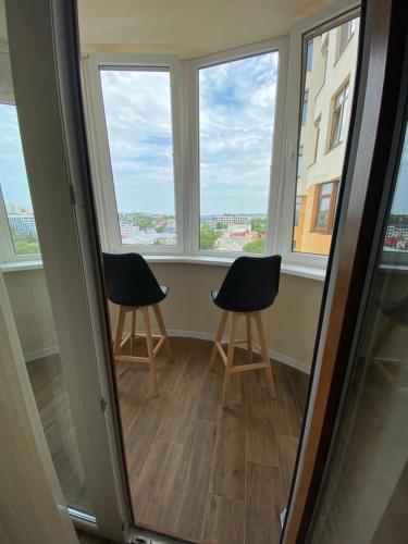 two chairs sitting in a room with windows at Нові апартаменти по вулиці Роксолани16 in Truskavets