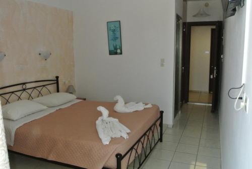 two swans sitting on a bed in a bedroom at Kokalakis Hotel in Kefalos