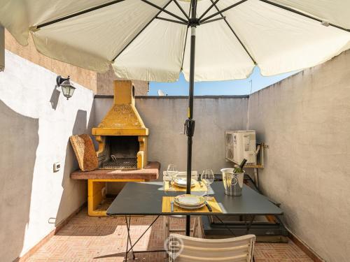 - une table avec un parasol sur la terrasse dans l'établissement Maty's House - Dreaming Holiday, à Gonnesa