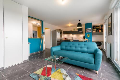 un salon avec un canapé bleu et une table dans l'établissement Le Fantasy, à Dijon