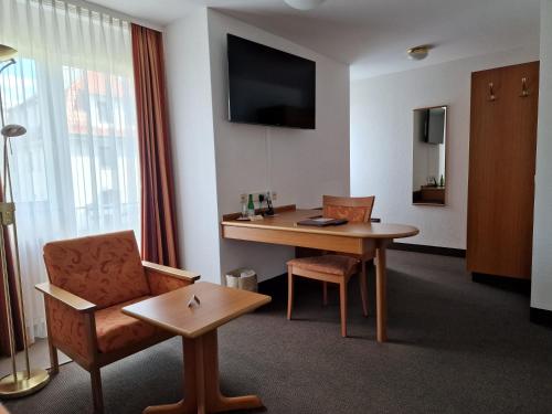 a hotel room with a desk and a chair at Hotel Gerberhof in Backnang