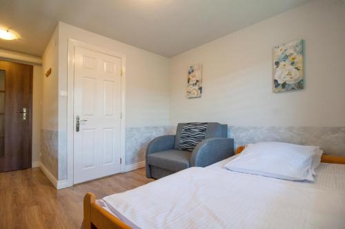 a bedroom with a bed and a chair at HELENOWO in Lutowiska