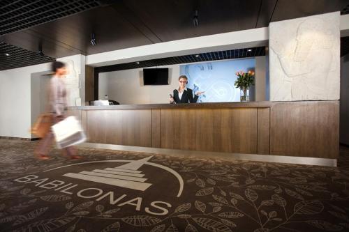 a man is standing at a bar in an office at Hotel Babilonas in Kaunas