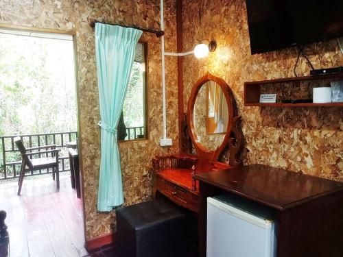 a bathroom with a sink and a mirror and a window at Tree Tops River Huts in Khao Sok National Park