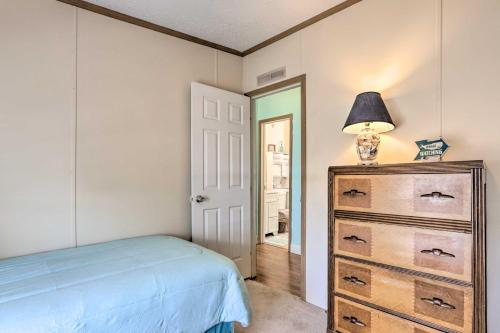 a bedroom with a bed and a dresser with a lamp at Steinhatchee Home with Boat Parking 1 Mi to Marina in Steinhatchee