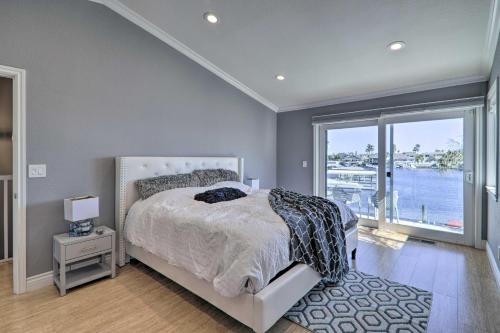 a bedroom with a bed and a large window at Discovery Bay Retreat with Balcony and Boat Dock! in Discovery Bay