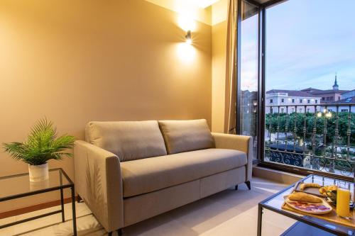 a living room with a couch and a large window at CASA Y FONDA 1888 in Alcalá de Henares