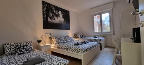a room with two beds and a couch at San Donato Policlinico BBking in San Donato Milanese