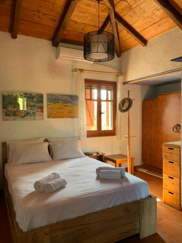 sypialnia z dużym łóżkiem z ręcznikami w obiekcie Mavilia Traditional Guesthouse w mieście Ligourio