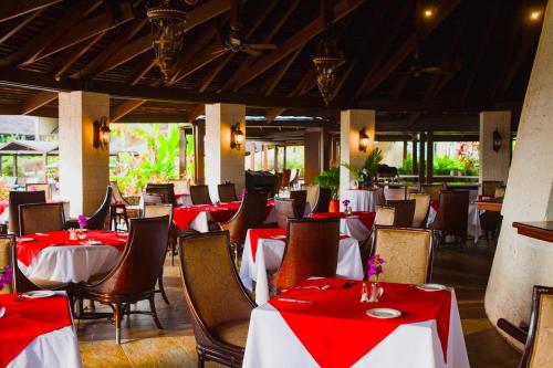 un restaurante con mesas y sillas rojas y blancas en Mount Irvine Bay Resort, en Grafton