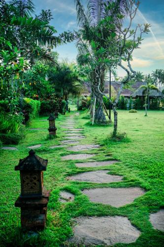 a stone path in a park with trees at Adil Villa & Resort in Ubud