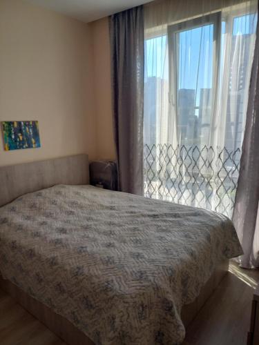 een slaapkamer met een bed en een groot raam bij Tamas house in Batoemi