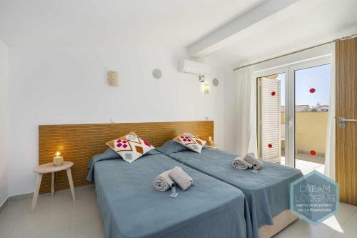 um quarto com 2 camas e lençóis azuis em Villa Rafaella 3 Dream Lodging em Albufeira