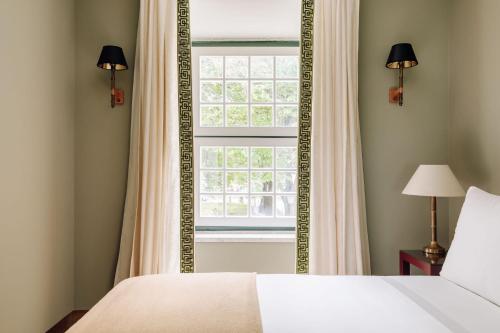 a bedroom with a large mirror and a window at Hotel das Amoreiras - Small Luxury Hotels of the World in Lisbon