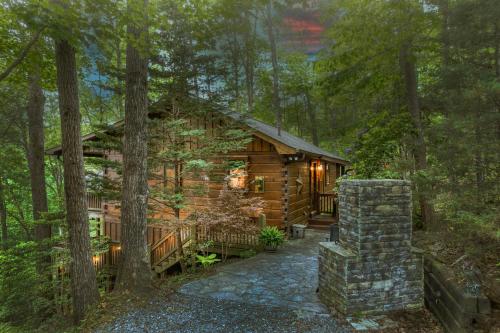 eine Blockhütte im Wald mit einem Steingang in der Unterkunft Secluded Sunrise Ridge-10 Min From Blue Ridge, King Beds, Hot Tub, 2 Porches, Fireplace Wood Burning, Mountain View, Cozy in Blue Ridge