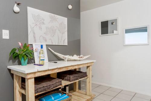 a bathroom with a console table and a painting on the wall at Ocean Blue at Chakas Cove, Beachfront Apartment in Ballito