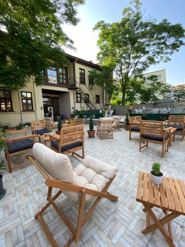 een patio met houten stoelen, tafels en banken bij Oasis Hotel Edirne in Edirne