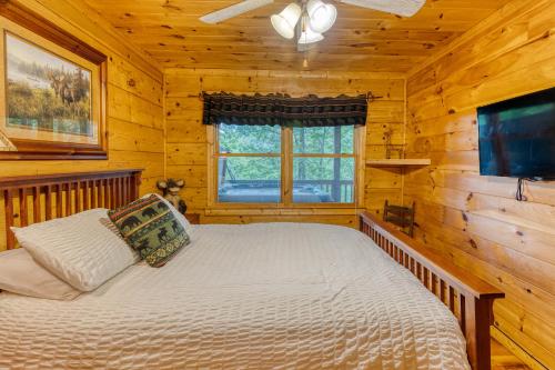 a bedroom with a bed in a log cabin at Secluded Sunrise Ridge-10 Min From Blue Ridge, King Beds, Hot Tub, 2 Porches, Fireplace Wood Burning, Mountain View, Cozy in Blue Ridge