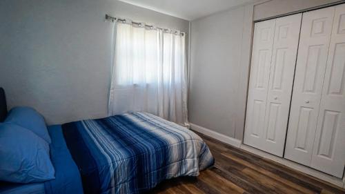 a bedroom with a blue bed and a window at Elegant Cozy Oasis on a traffic free street in Clearwater