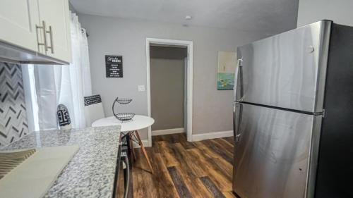 a kitchen with a stainless steel refrigerator and a table at Elegant Cozy Oasis on a traffic free street in Clearwater