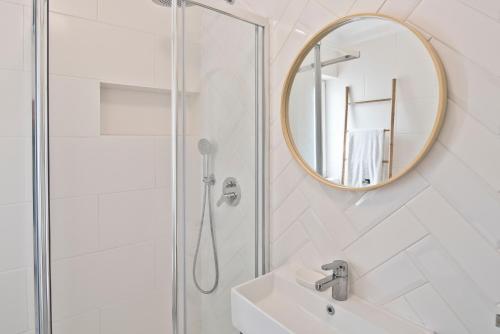 エリセイラにあるBmyGuest - Ericeira Typical Apartmentのバスルーム(シャワー、シンク、鏡付)