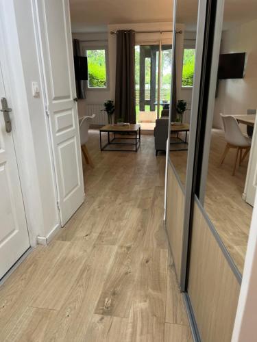 a living room with a wooden floor and a mirror at LE COSY Résidence du Golf in Deauville