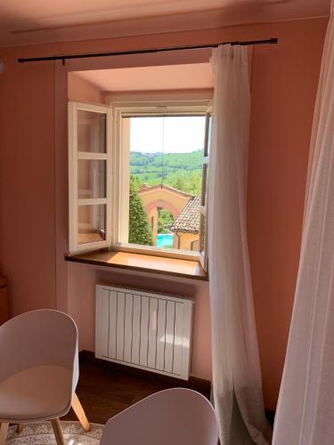 a window with a white curtain in a room at Borgo La Morra in Pavullo nel Frignano