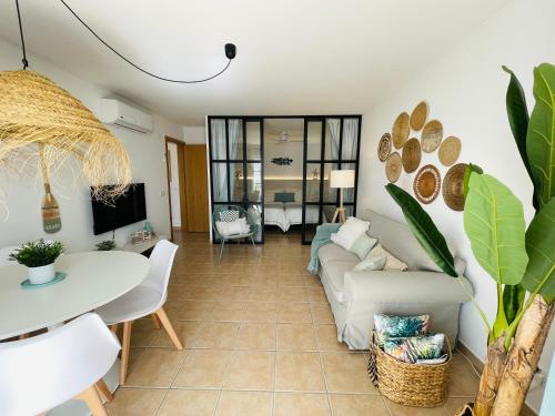 ein Wohnzimmer mit einem Sofa und einem Tisch in der Unterkunft Fantástico apartamento T2 a 2min do acesso à praia CozyIn Cabanas in Cabanas de Tavira