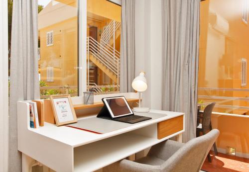 einen Schreibtisch mit einem Laptop und einem Fenster in der Unterkunft Albers Apartment in Port d'Alcúdia