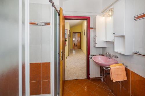 łazienka z różową umywalką i korytarzem w obiekcie Bella Vista w Poreču