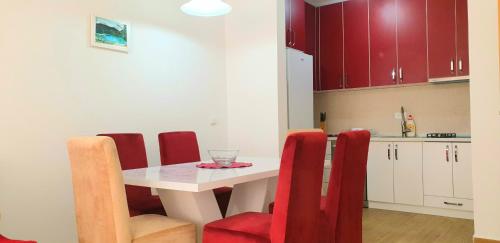 een keuken met een witte tafel en rode stoelen bij Apartment Vasilije in Žabljak