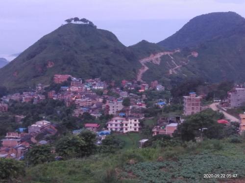 a town on a hill with mountains in the background at Good Hotel in Bandīpur