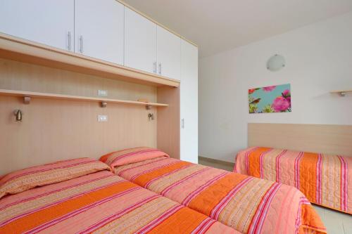 dos camas sentadas una al lado de la otra en un dormitorio en Appartamenti Fiore, en Lignano Sabbiadoro