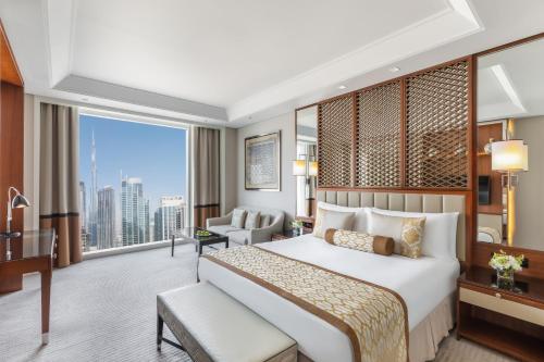 a hotel room with a bed and a large window at Taj Dubai in Dubai