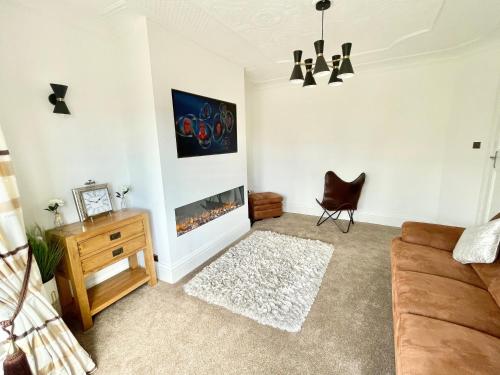 uma sala de estar com um sofá e uma lareira em Croyden villa em Blackpool