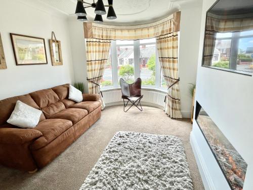 a living room with a brown couch and a tv at Croyden villa in Blackpool