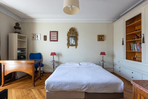 une chambre avec un lit, un bureau et une table dans l'établissement Veeve - Plumes in the Park, à Paris