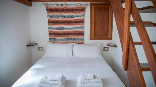 1 dormitorio con 1 cama y 2 toallas blancas en Welcomely - Country House Muristene, en Dorgali