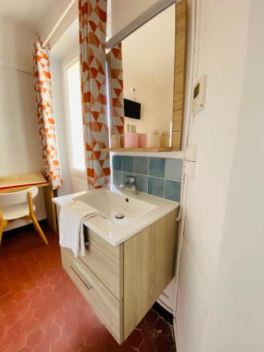 a bathroom with a sink and a mirror at Villa TerraMera Hôtel in Le Lavandou